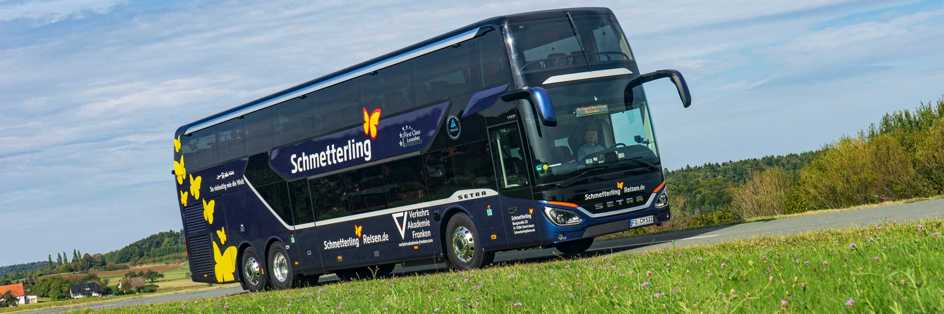 Doppeldecker-Reisebus fährt in schöner Landschaft